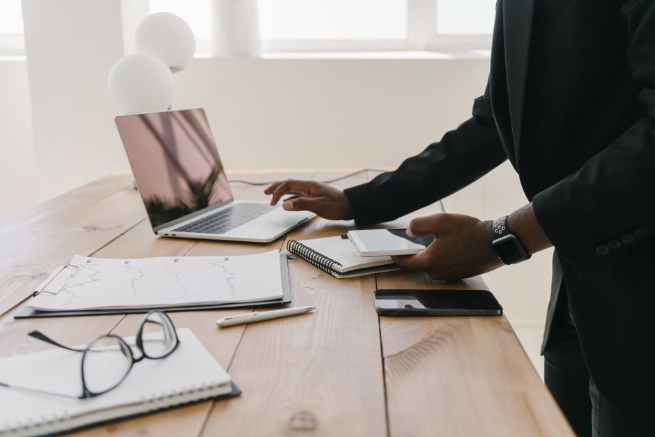 Professional workspace with a laptop, documents, and stationery on a wooden table.